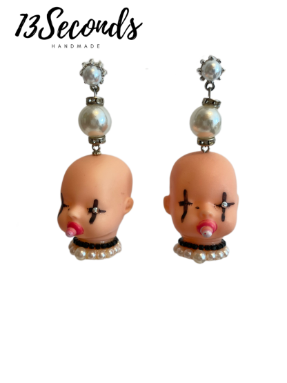 Pendientes hechos a mano con forma de cabeza de muñeca.